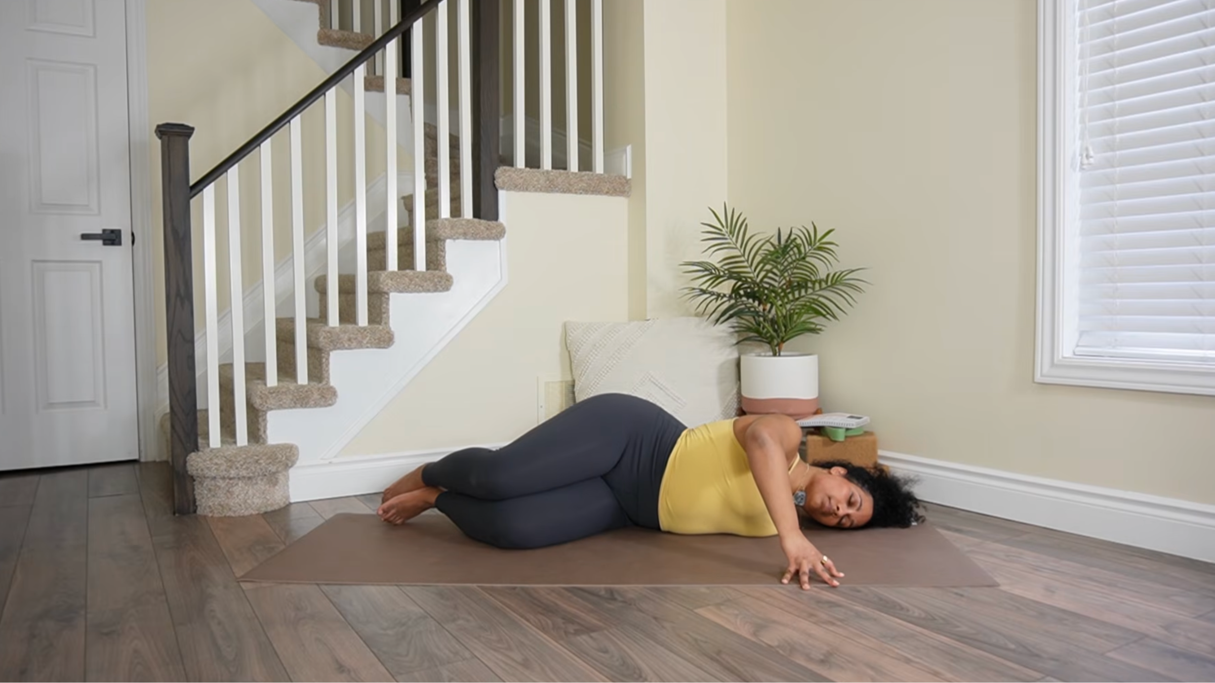 Yoga teacher practicing Broken Wing variation.